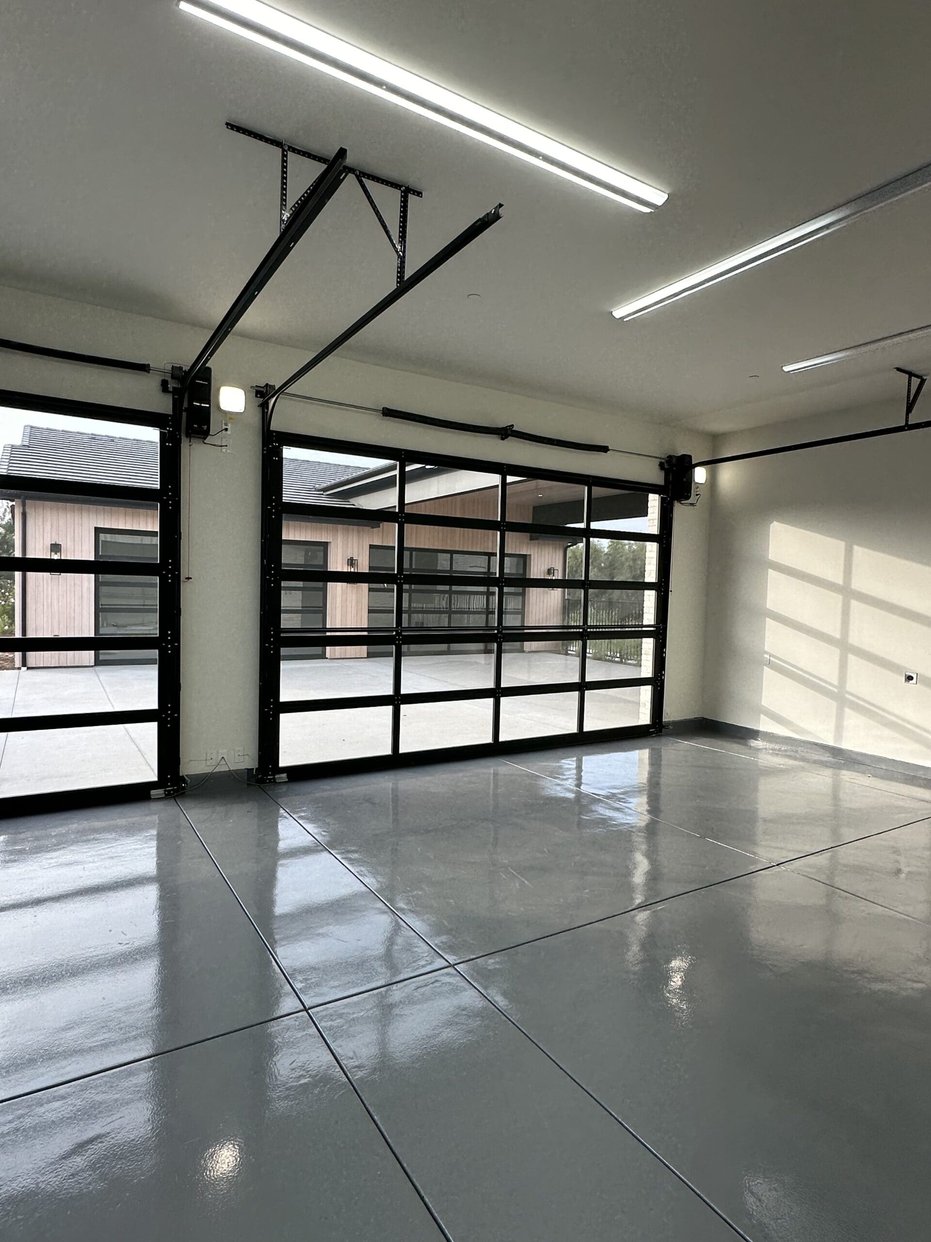 Spacious garage with smart glass doors and modern automation features Spacious garage with smart glass doors and modern automation features.
